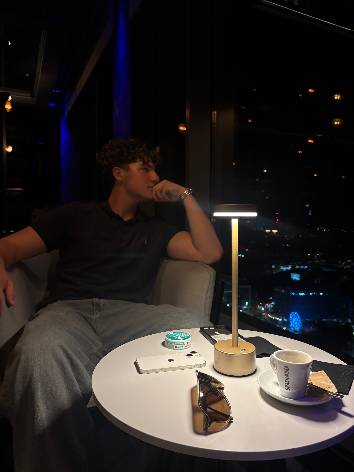 Dawid Turoń siedzący przy stoliku w restauracji nocą